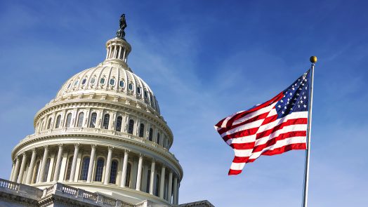 American flag waving with the Capitol Hill in the background