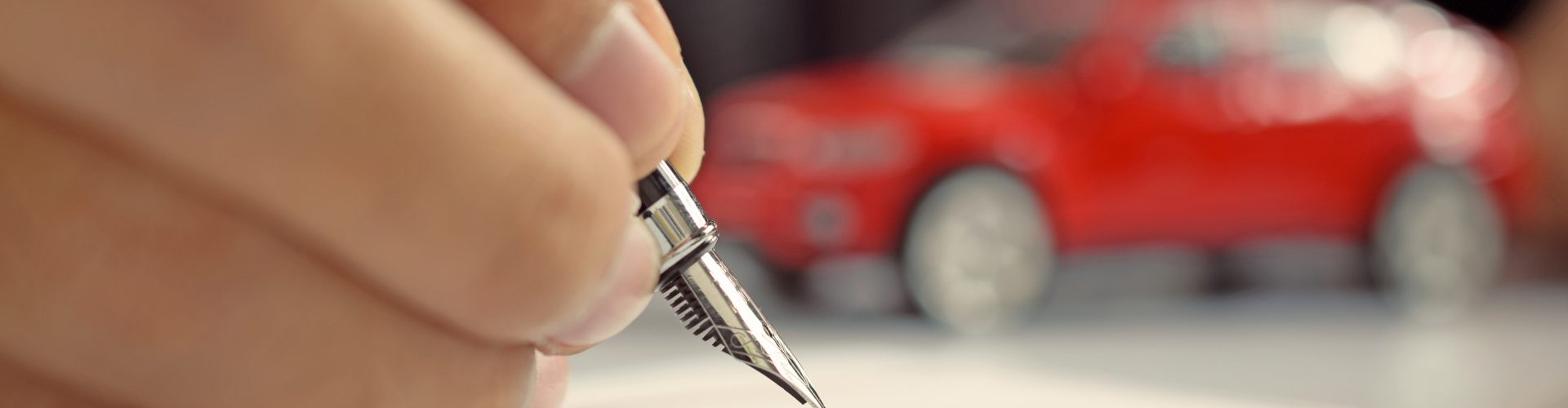 Man signing car insurance document. Writing signature on contract or agreement. Buying or selling new or used vehicle.