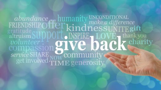 female open hand gesturing towards the words GIVE BACK surrounded by a relevant word cloud against a blue bokeh background