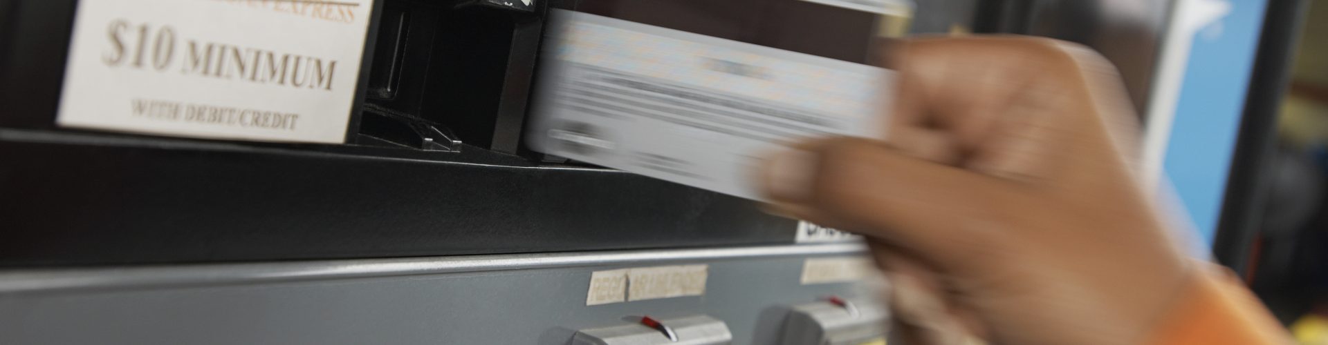Person paying with credit card at gas pump, motion blur