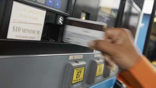 Person paying with credit card at gas pump, motion blur