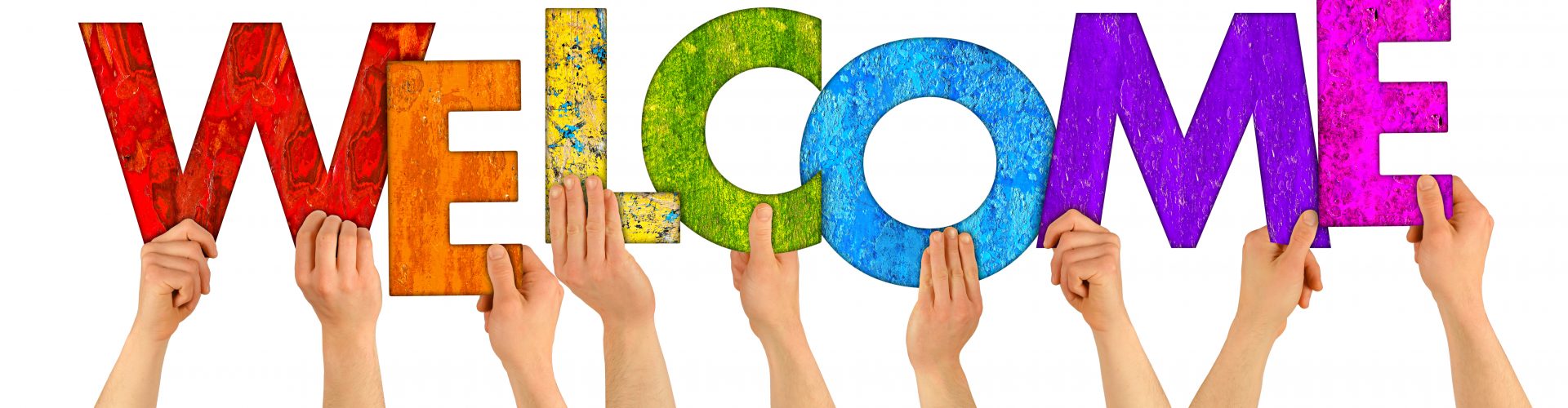 hands holding up colorful wooden letters shaping the word welcome isolated on white background
