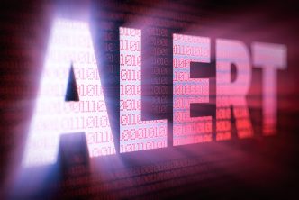 ALERT bright glowing word on computer screen filled with red binary code