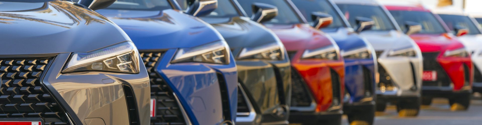 Sitges, Spain - 26th February, 2019: Lexus UX (Toyota Group) SUV vehicles in hybrid version parked on the public parking before the drives. The UX model is the smallest crossover in the Lexus offer. Focus is on the first car on the left.