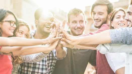 Young happy people stacking hands outdoor - Diverse culture students celebrating together - Youth lifestyle, university, relationship, human resorces, work and friendship concept - Focus on hands