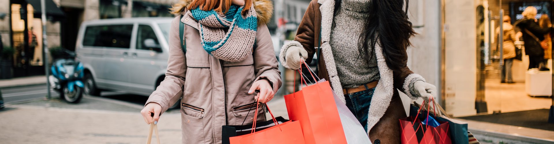 Happy two girls holding bunch of shopping bags