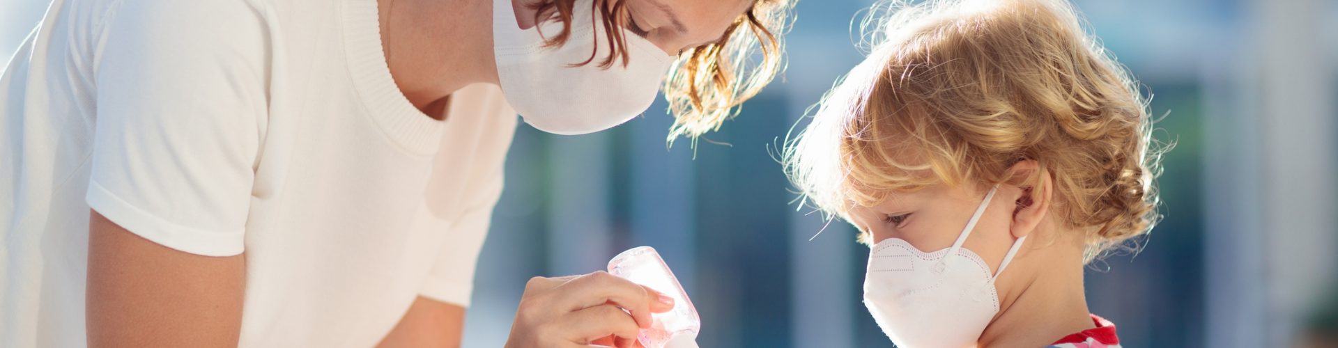 Family with kids in face mask in shopping mall or airport. Mother and child wear facemask during coronavirus and flu outbreak. Virus and illness protection, hand sanitizer in public crowded place.