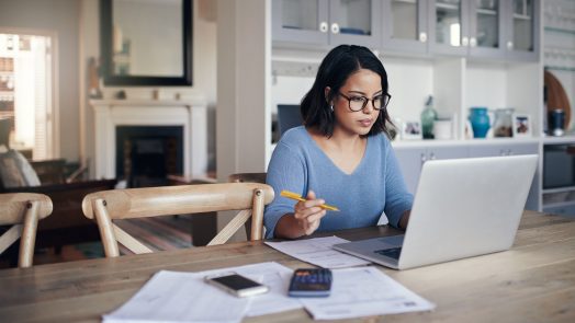 Shot of a young woman using a laptop while working from home