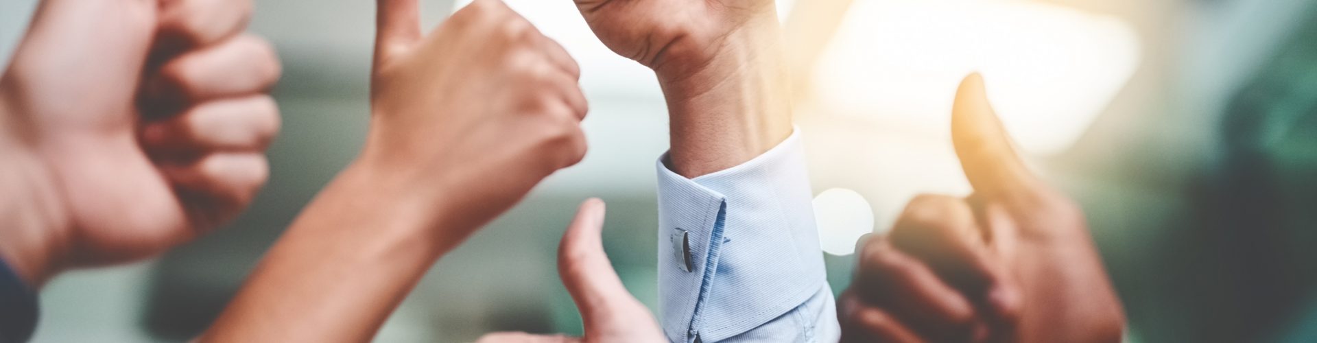 Cropped shot of a group of unrecognizable businesspeople showing thumbs up in an office