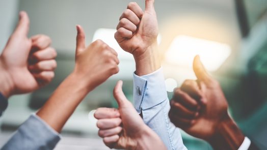 Cropped shot of a group of unrecognizable businesspeople showing thumbs up in an office