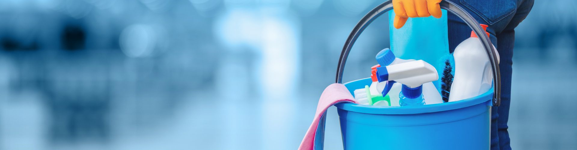Concept of quality cleaning. The cleaning lady standing with a bucket and cleaning products.