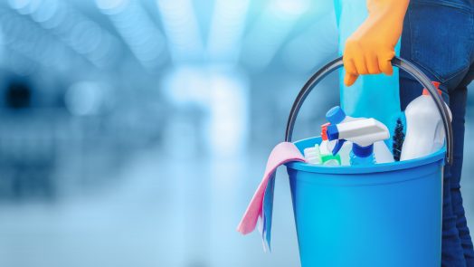 Concept of quality cleaning. The cleaning lady standing with a bucket and cleaning products.