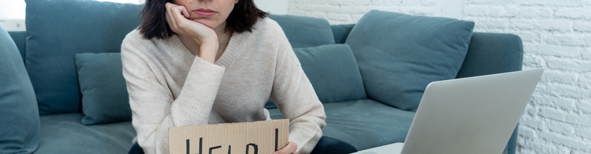 Portrait of worried young woman feeling stressed and desperate asking for help in paying bills, debts, tax expenses and accounting home finances with laptop. In online banking and financial problems.