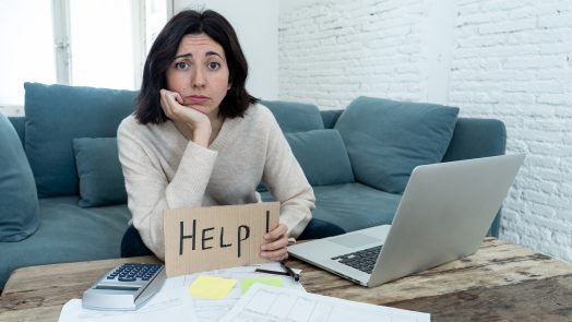 Portrait of worried young woman feeling stressed and desperate asking for help in paying bills, debts, tax expenses and accounting home finances with laptop. In online banking and financial problems.