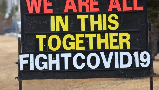 A sign or billboard in front of a business that states we are all in this together fight Covid-19.