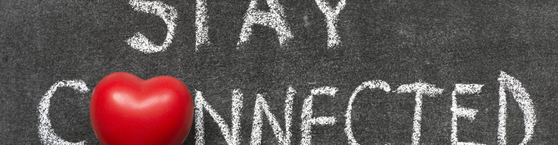 stay connected phrase handwritten on blackboard with heart symbol instead of O