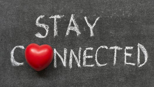 stay connected phrase handwritten on blackboard with heart symbol instead of O