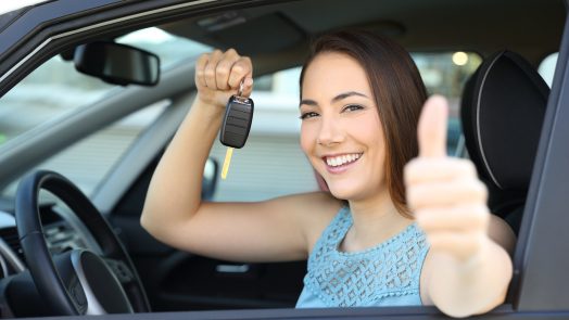Happy car owner with a key and thumbs up